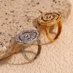 Detail of 18K gold and silver rose rings with pave diamonds on beige stone background