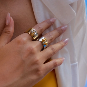 Close-up of dual-tone 18k gold and silver stainless steel wide heart open rings on model