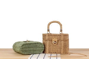 Detail of green woven clutch and khaki straw suitcase bag with gold chain straps