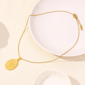 Detailed macro view of an oval Tree of Life pendant on a golden stainless steel chain