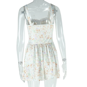 Detailed view of floral print pattern on cream V-neck mini dress with wide straps