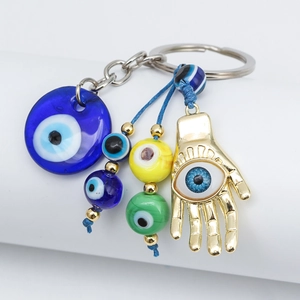 Detailed close-up of the Hamsa Hand and evil eye charms on the golden keychain link