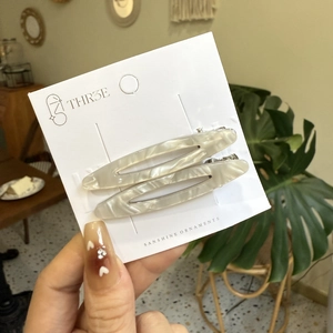 Paire de barrettes à motif marbre blanc en acétate, forme ovale creuse sur carte