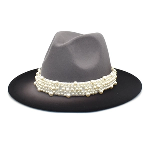 Close-up of dual-tone fedora hat featuring grey crown and pearl-embellished band
