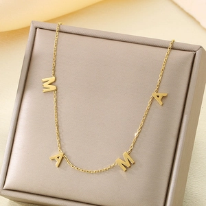 Close-up of 18K gold-plated MAMA letter pendant necklace in a premium gift box