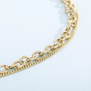 Detailed close-up of double-layered gold chains featuring thick and thin link designs