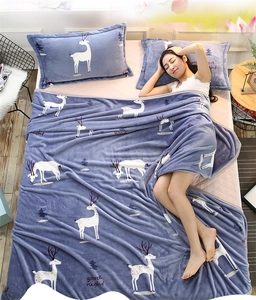 Gros plan de couverture en flanelle douce avec rennes blancs et arbres sur tissu bleu-gris