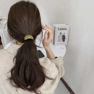 Minimalist avocado green resin hair tie styled on a ponytail for an elegant look