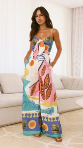 Detail view of abstract digital print jumpsuit with waist tie in home setting