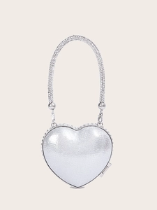 Detail of a silver heart-shaped evening bag featuring a luxury sparkling rhinestone handle