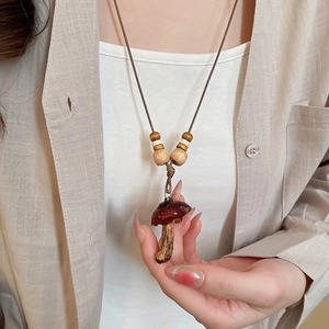 Close-up of vintage resin mushroom pendant with wood beads and dark red glazed cap