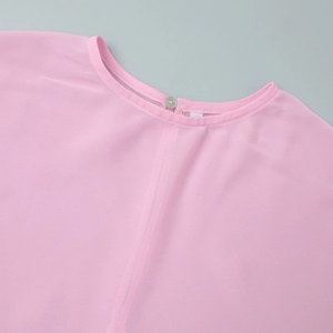 Detail van de roze chiffon halslijn met ronde kraag en knoopsluiting op de rug
