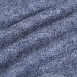 Texture macro du tissu en laine tricotée bleue avec coutures fines et plis doux