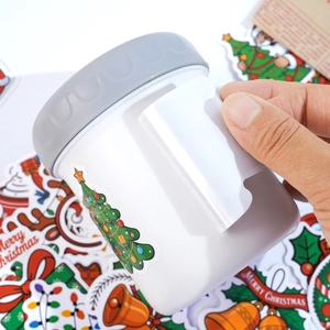 Detail of white mini trash can with grey lid, handle view and Christmas tree stickers