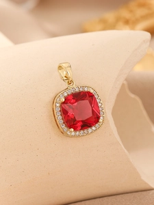 Macro shot of square gold pendant featuring red gemstone and clear cubic zirconia
