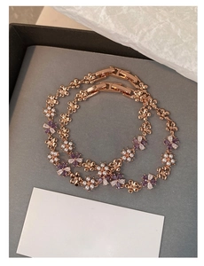 Detailed macro view of rose gold flower bracelet with zircon stones and pearls