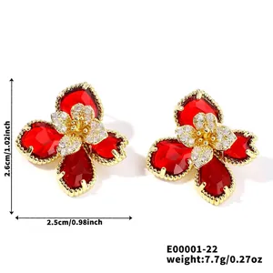 Vue macro de boucles d'oreilles fleurs avec pétales rouges et centre en zircon