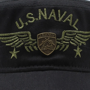 Close-up of black military flat top hat with U.S. NAVAL embroidery and bronze badge