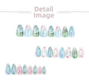 Macro view of almond press-on nails with floral patterns and cat scenery details