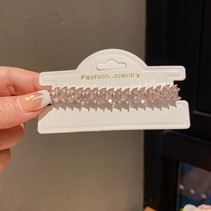 Detailed macro shot of dual-row pink heart-shaped crystal bracelet on display card