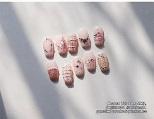 Detail view of 10pcs pink press-on nails with 3D pearls and cute bear illustrations