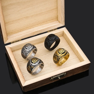 Nordic Viking Thor hammer rings in gold, silver, and black on a rustic wooden jewelry box