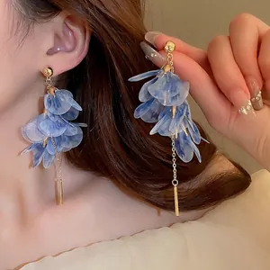 Elegant long blue flower tassel earrings with mesh petals and gold chain on model