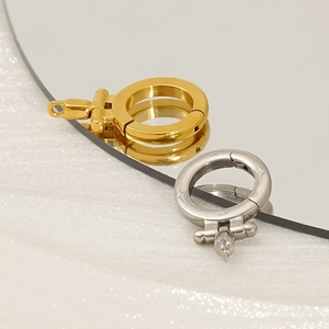 Polished gold and silver horseshoe-shaped clasp connectors on white satin background