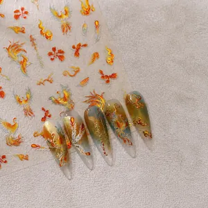 Gedetailleerde macro-opname van gouden feniks nagelstickers op lange kunstnagels.