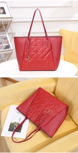 Detail of red quilted faux leather tote bag with elegant metallic ring charm
