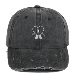 Detail of washed cotton baseball cap with heart embroidery and distressed brim edge