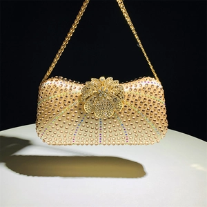 Detailed view of luxury gold evening clutch with rhinestones and floral metal clasp