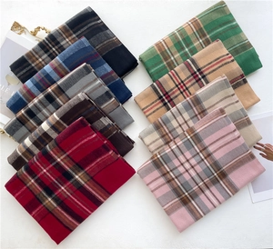 Vista dettagliata di sciarpe a quadri piegate in vari colori e morbida trama cashmere