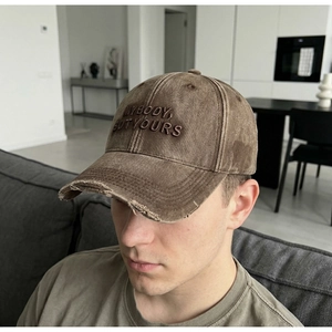 Detail of vintage washed baseball cap featuring 3D embroidery and distressed brim edge