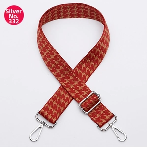 Close-up of wide red and yellow woven guitar strap with silver metal swivel hooks