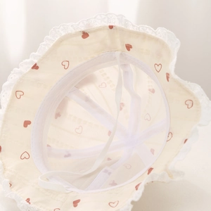 Detail view of cotton baby sun hat lining with heart print, lace trim and chin strap