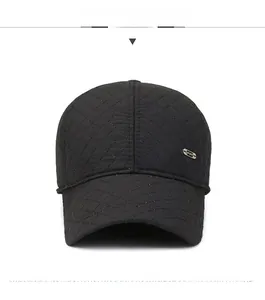 Close-up of black quilted baseball cap with Sport metal badge and thick thermal fabric