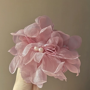 Nahaufnahme der rosa Organza-Blumen-Haarklammer mit zarten Doppelperlen in der Mitte