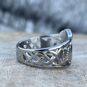Gros plan d'une bague celtique argentée avec gravure de bouclier sur bois rustique