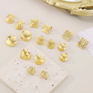Sammlung minimalistischer goldener Herz- und geometrischer Ohrringe auf einem Steintablett