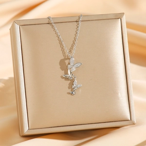 Élégant collier papillon en argent avec zircons étincelants sur de la soie champagne