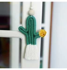 Detailed close-up of handmade woven cactus keychain with wooden beads and white tassel