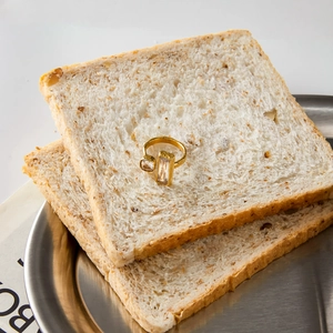 Detail view of 18K gold stainless steel open ring with dual rectangular cut crystals