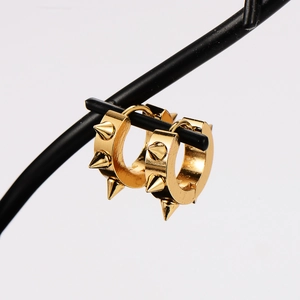 Close-up of golden spike hoop earrings with sharp cone studs on a black jewelry stand