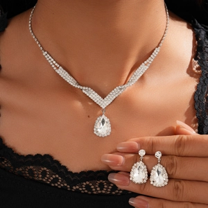 Close-up of sparkling teardrop-shaped crystal necklace and earrings on female model