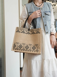 Chic model style with large jute tote bag featuring black geometric ethnic patterns