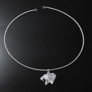 Macro view of silver leopard head pendant with sparkling stones on twisted chain