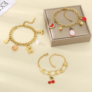Detail of three 18K gold fruit charm bracelets featuring enamel watermelon and pineapple