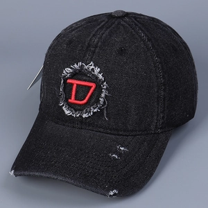 Dettaglio ravvicinato del cappellino in denim lavato con logo D ricamato in rosso