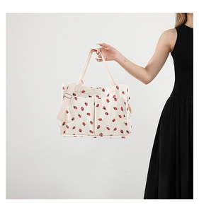 Detail of strawberry print corduroy tote with dual front pockets and shoulder strap